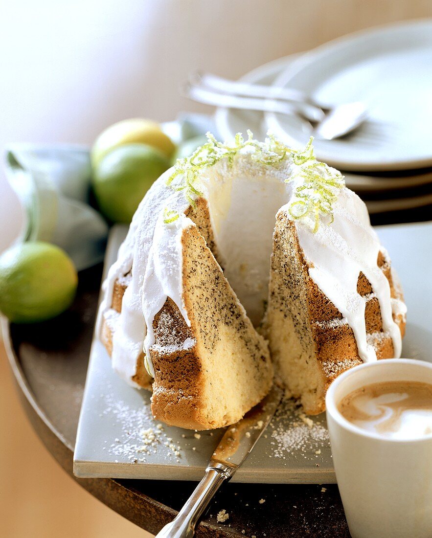 Limetten-Mohn-Kuchen mit weißem Zuckerguss; Kaffee