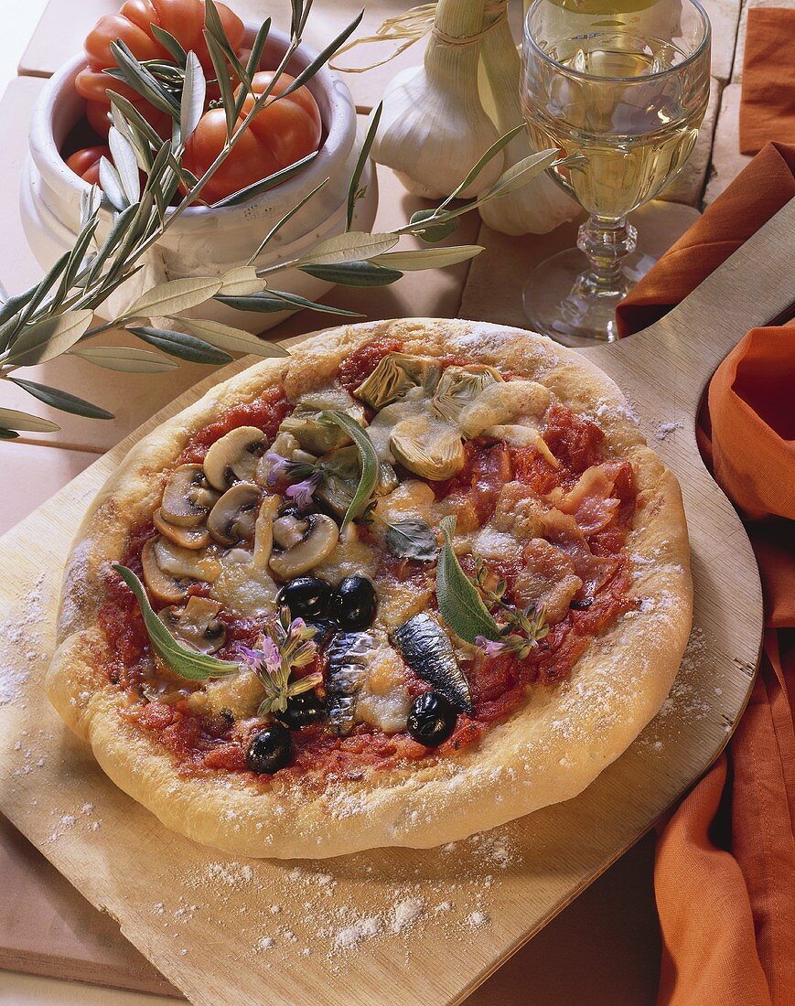 Pizza mit Artischocken, Fisch und Pilzen auf Backschaufel
