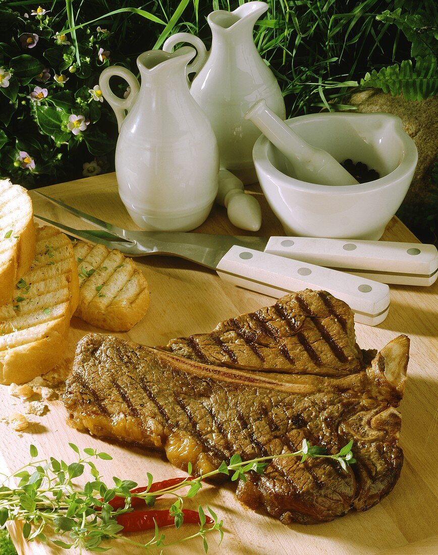 T-Bone-Steak auf Holzschneidebrett mit gegrilltem Weißbrot