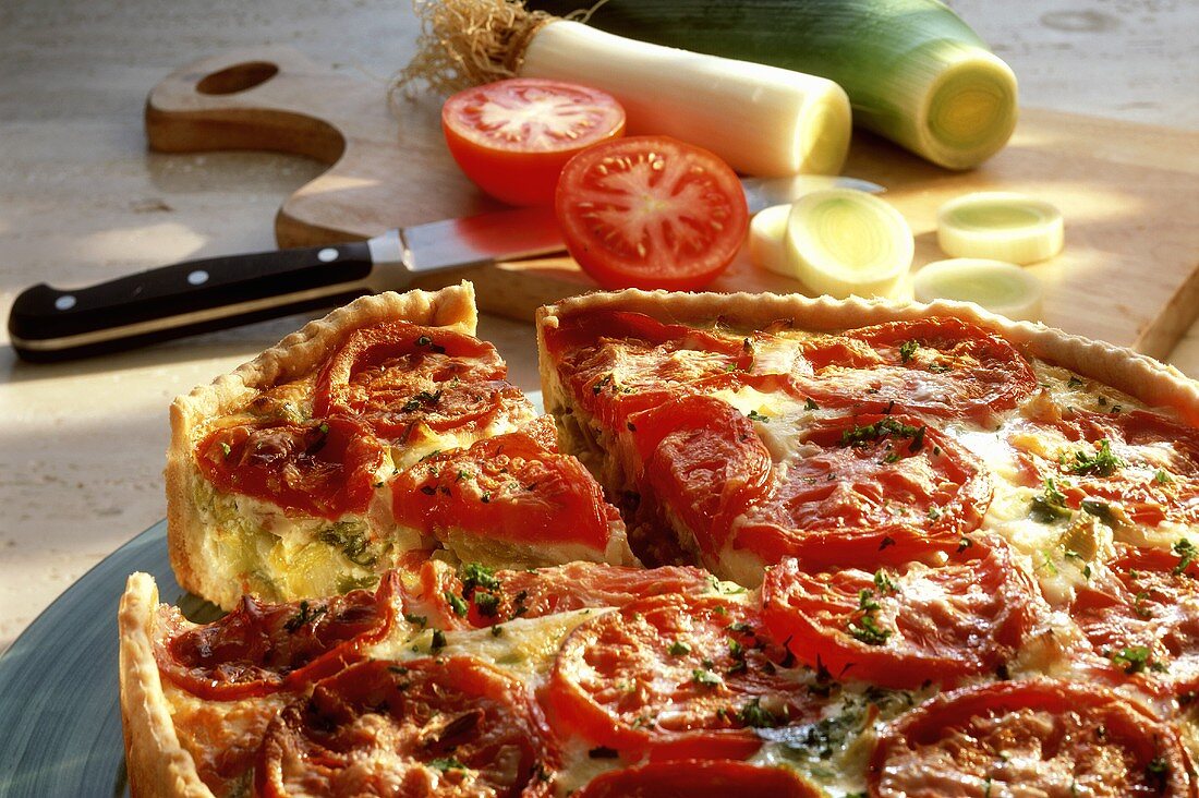 Quiche with tomatoes and leeks (a piece cut)