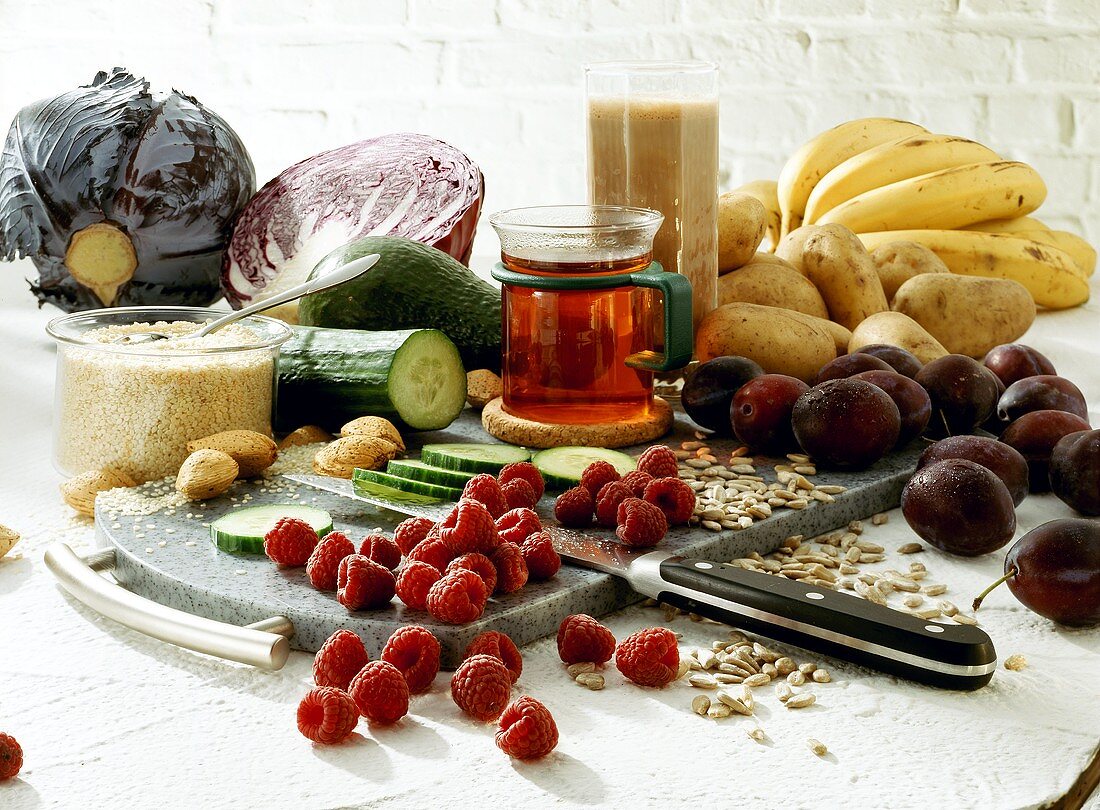 Still life with vegetables, sesame, raspberries, plums, tea 