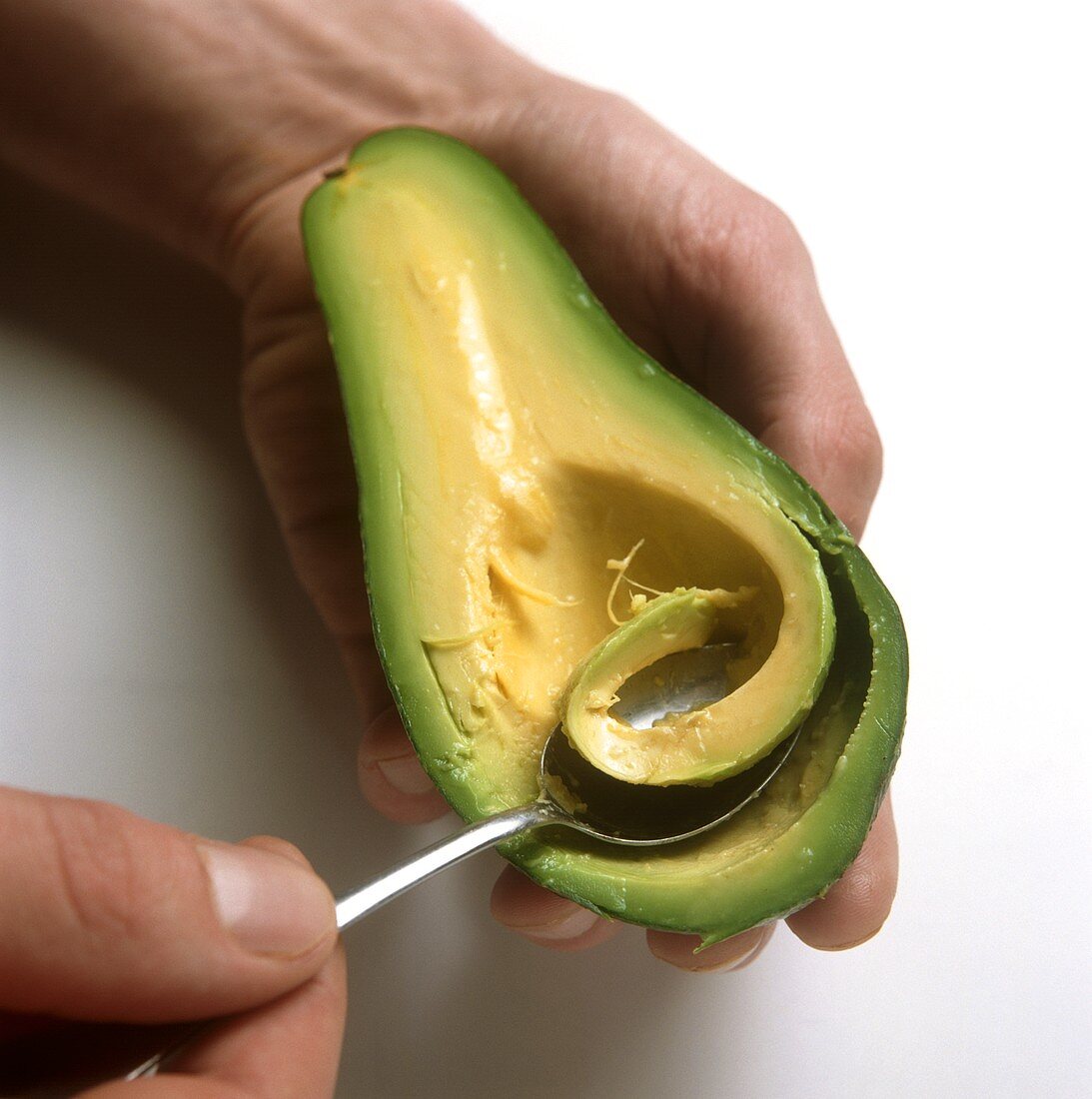 Hollowing out avocado with a spoon