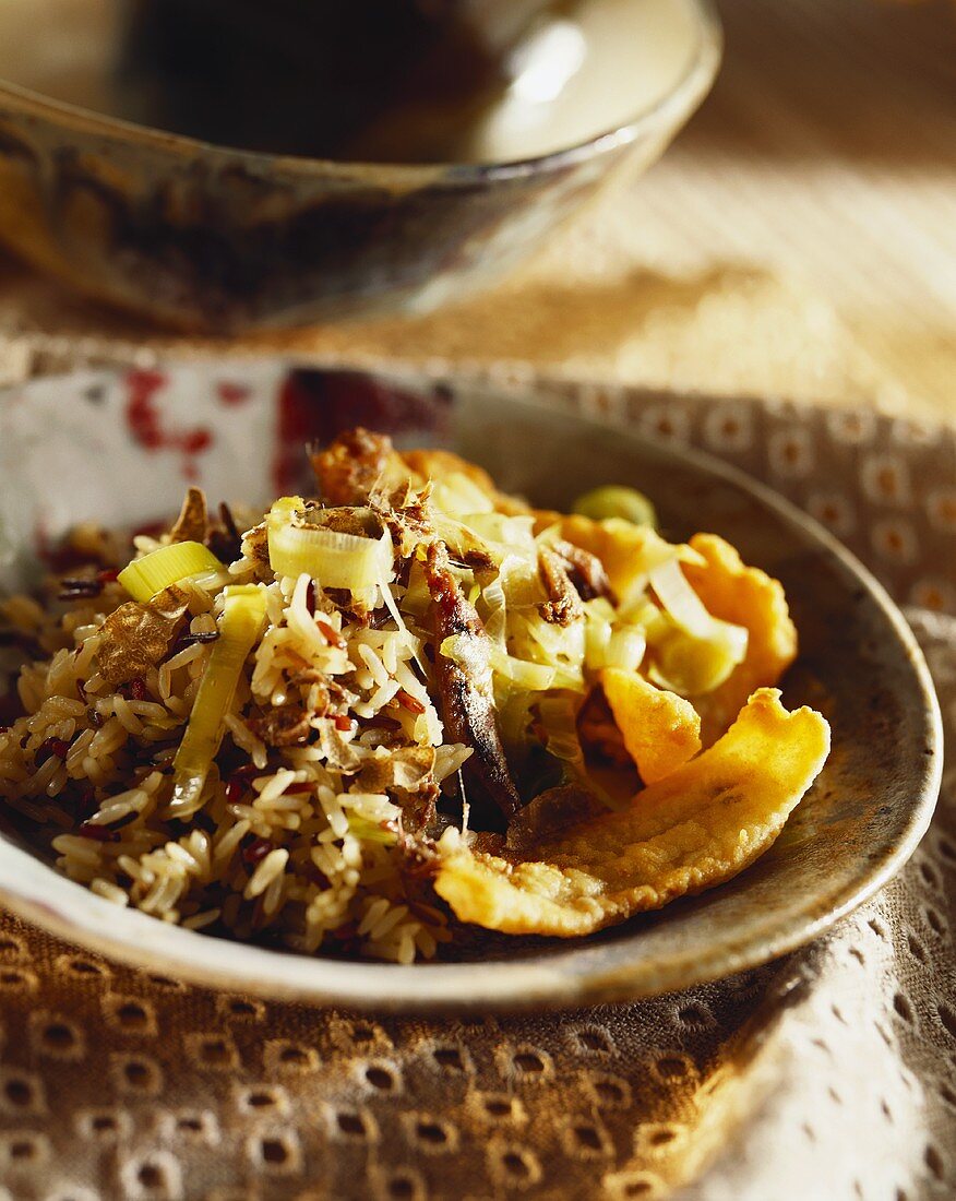 Reis mit fritierten Fischfilets und Lauch