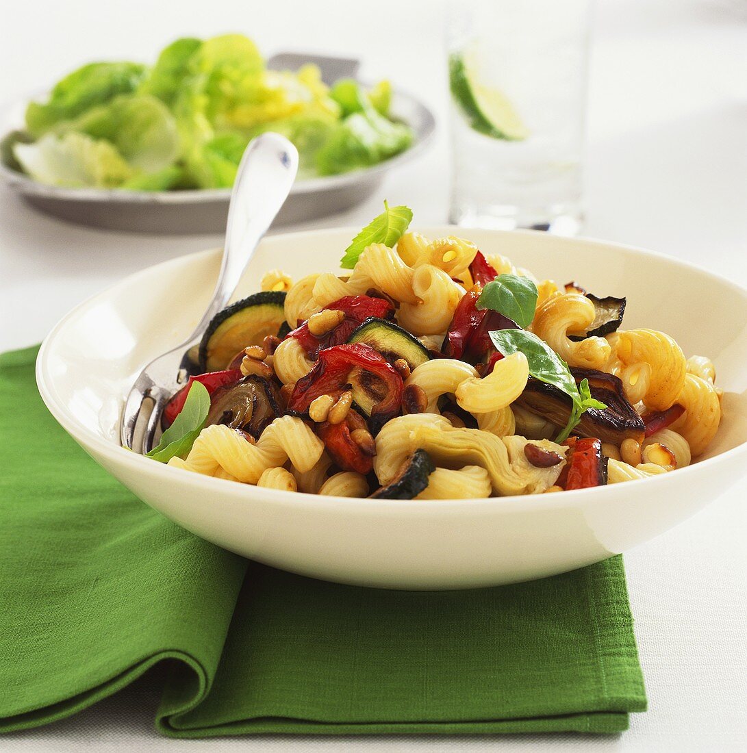 Pasta crescents with roasted vegetables and pine nuts