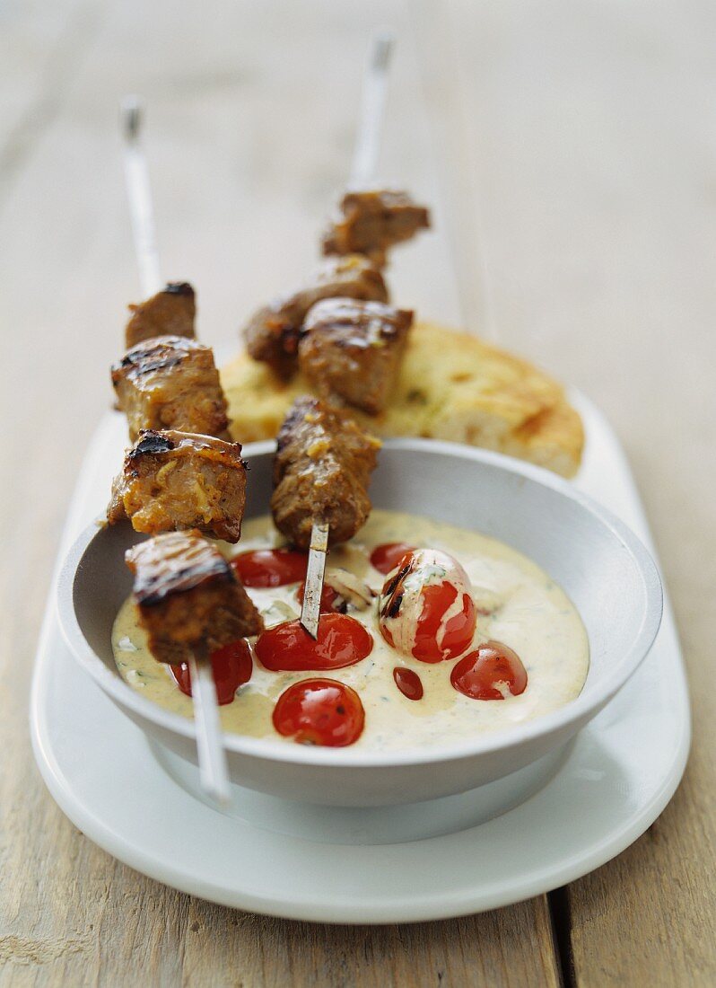 Meat kebabs with garlic sauce and cherry tomatoes