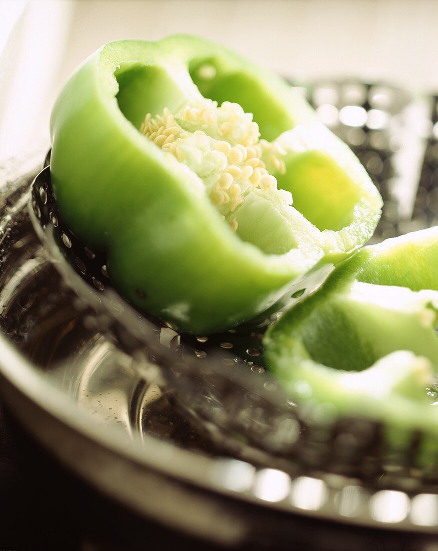 Halved green pepper on a strainer