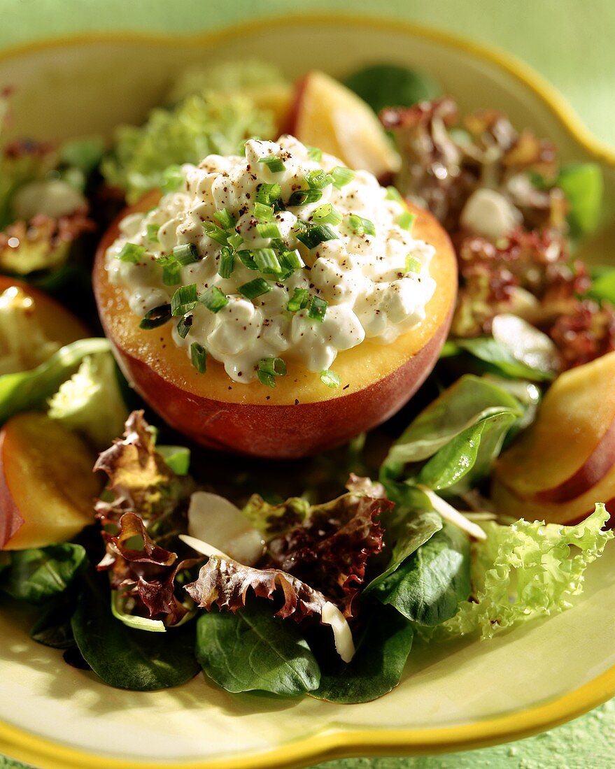 Peach stuffed with cottage cheese on mixed salad leaves