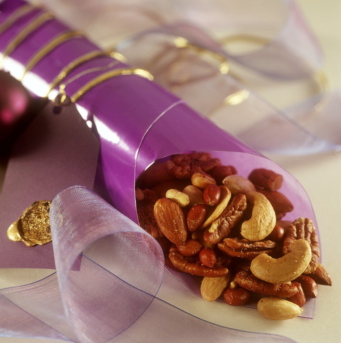 Gesalzene Nüsse in violetter Tüte als Weihnachtsgeschenk