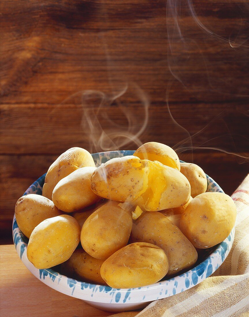 Steaming potatoes boiled in their skins, on plate
