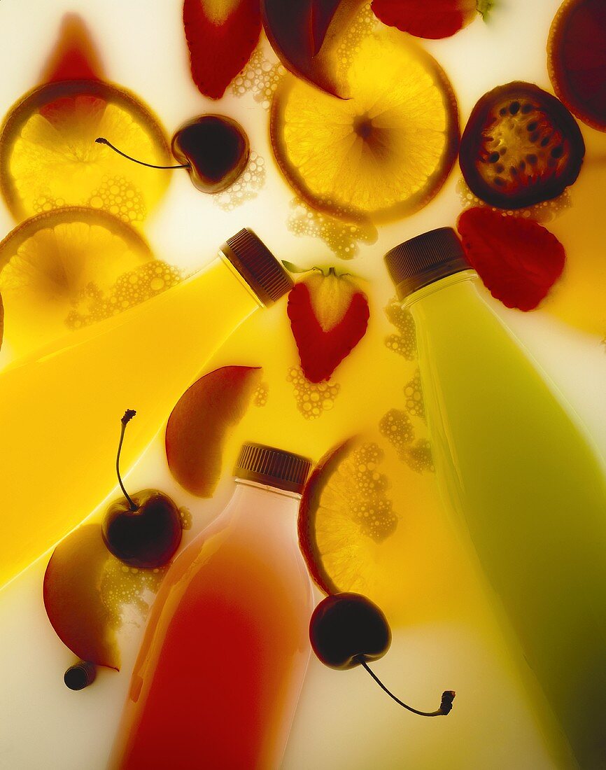 Yoghurt fruit drinks in bottles surrounded by fruit