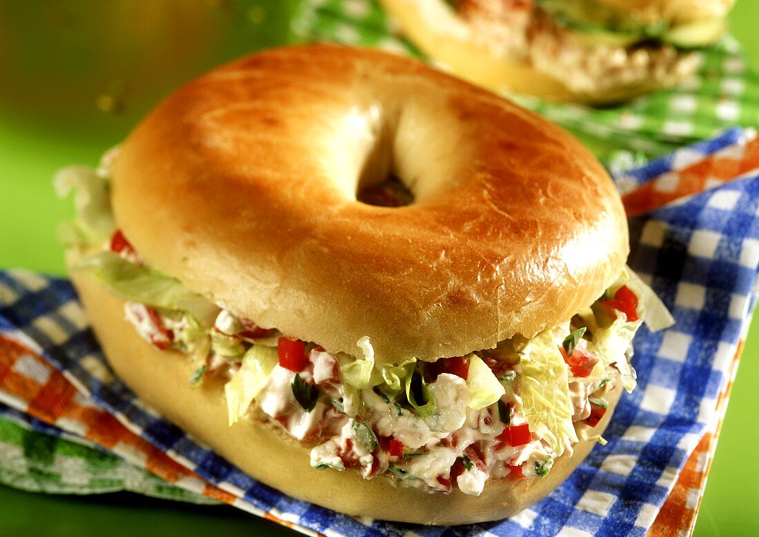 Bagel mit Schinkencreme auf karierten Servietten