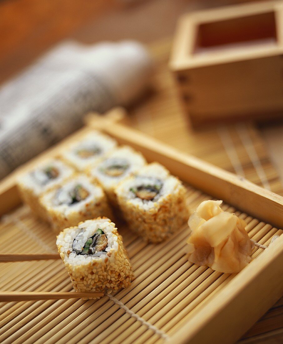 Ura maki (inside out roll) on bamboo tray with ginger