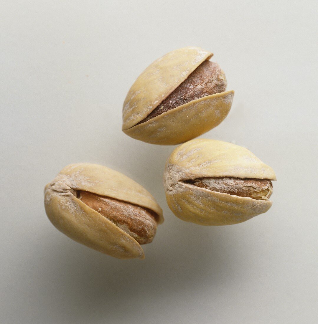 Three pistachio kernels with shell