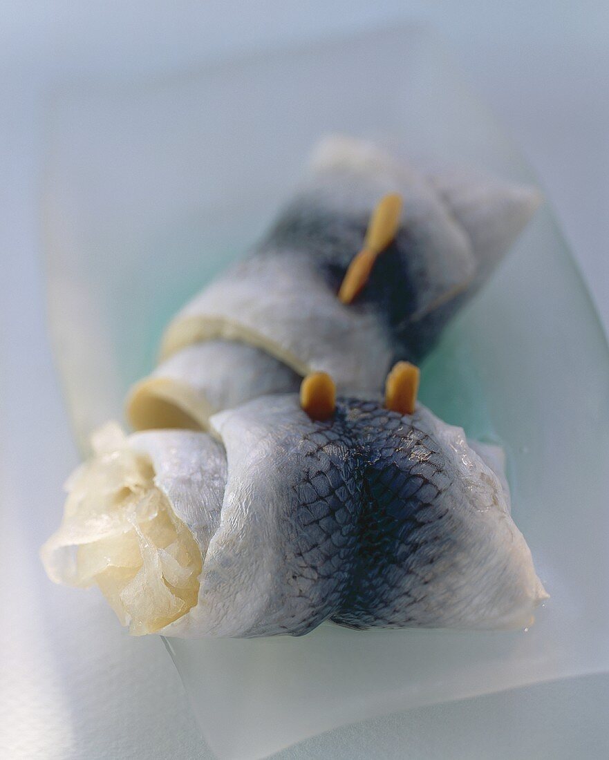 Two rollmops in a white dish