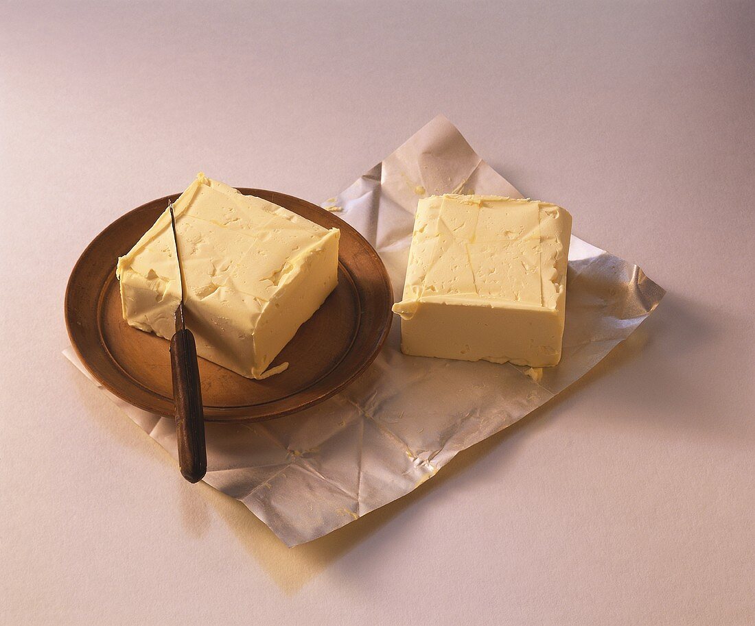 Butter auf Teller und Einwickelpapier