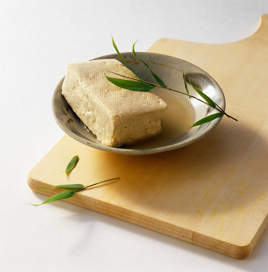 Smoked tofu in a bowl on chopping board