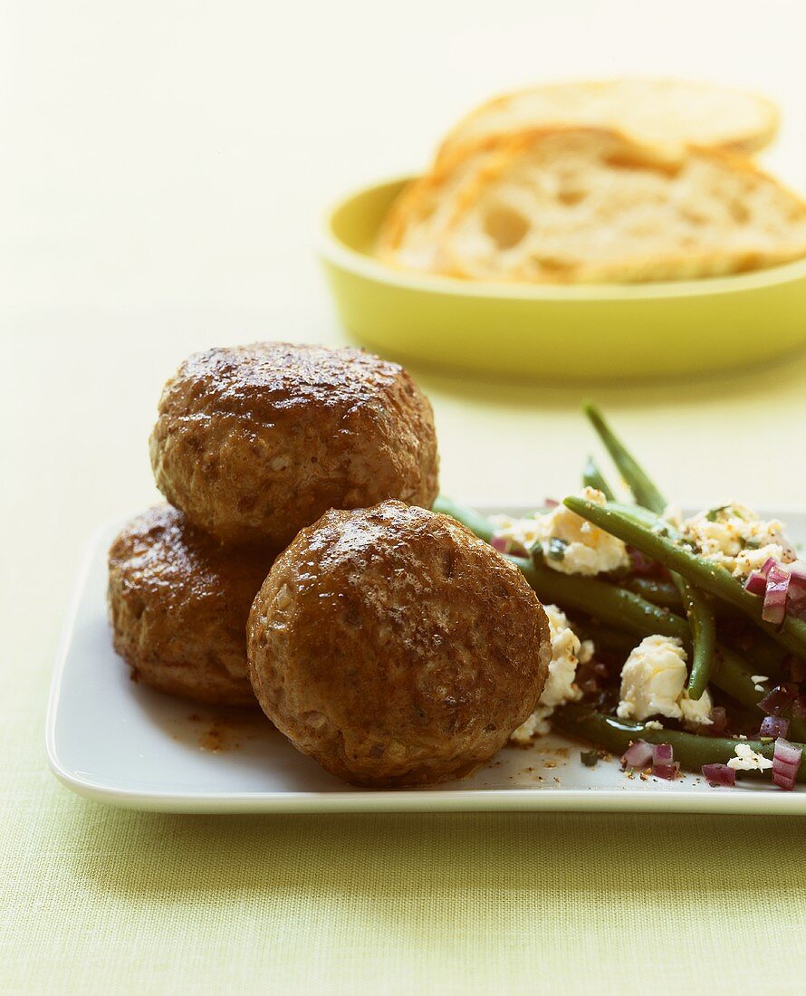 Lamm-Frikadellen mit marinierten Bohnen, Schafskäse und Brot