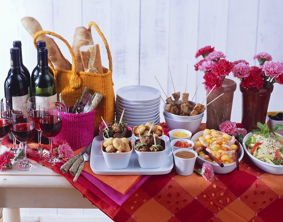 Tapas-Buffet mit Rotwein und Baguette; Deko: Blumen