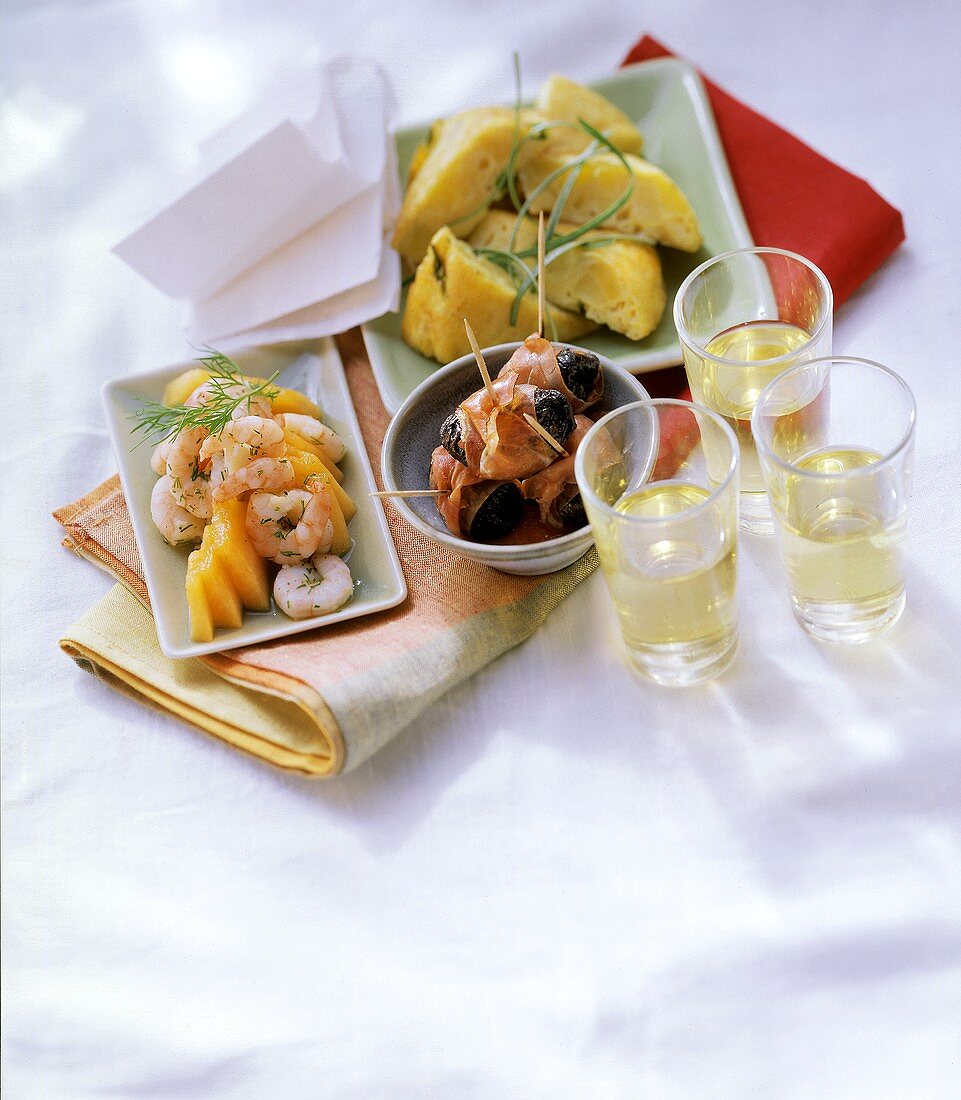 Various tapas in bowls on cloth; three sherry glasses