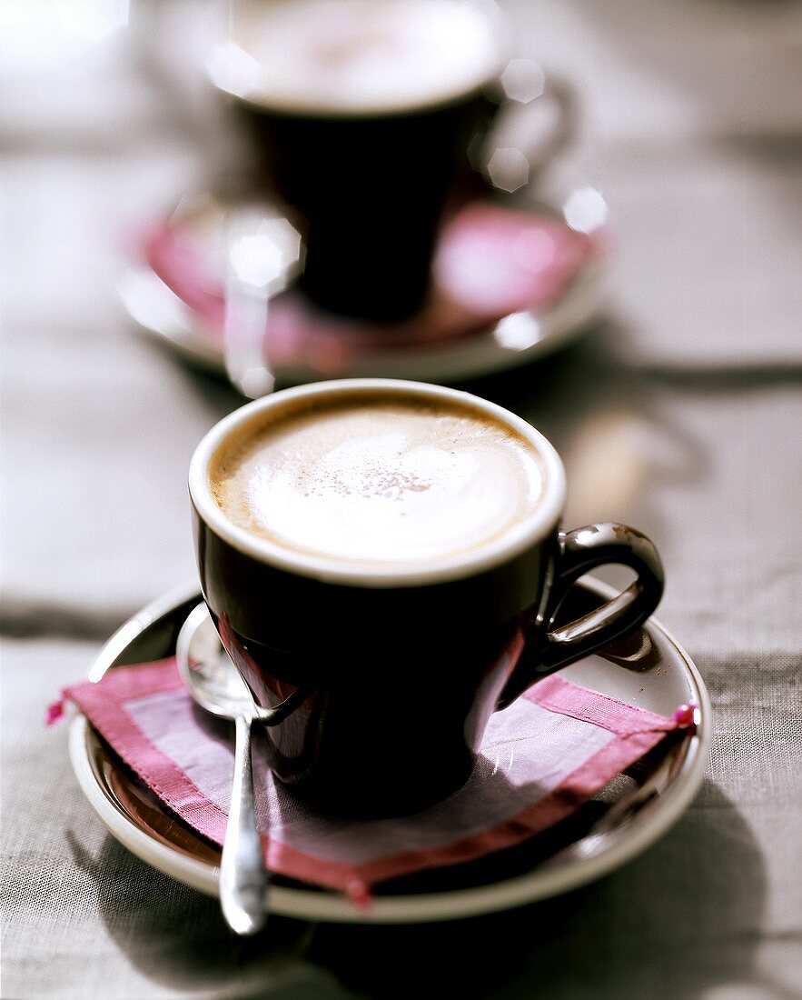 Cappuccino in brown espresso cups