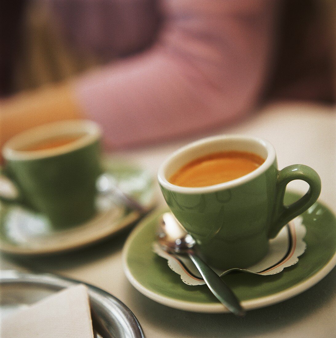 Espresso in zwei hellgrünen Tassen auf Tisch