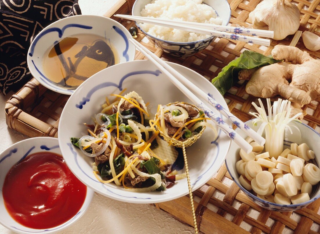 Chinesisches Fondue mit Fleisch, Gemüse, Glasnudeln und Reis