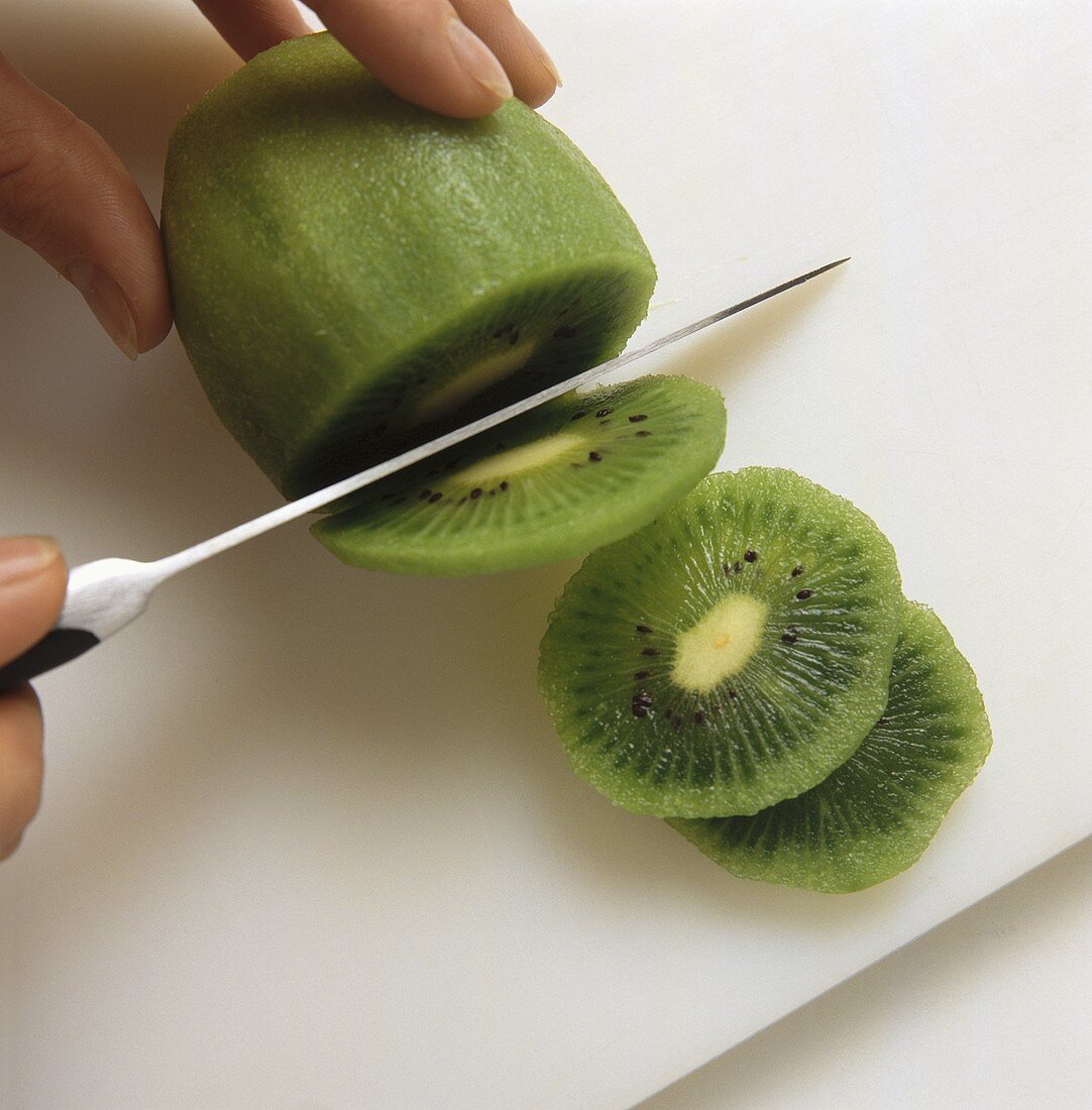 Geschälte Kiwi in Scheiben schneiden