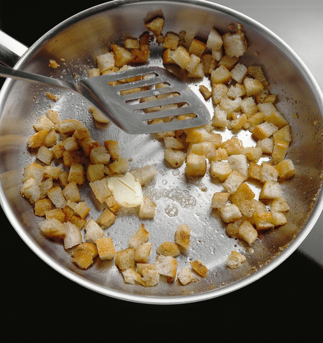 Tossing croutons in butter