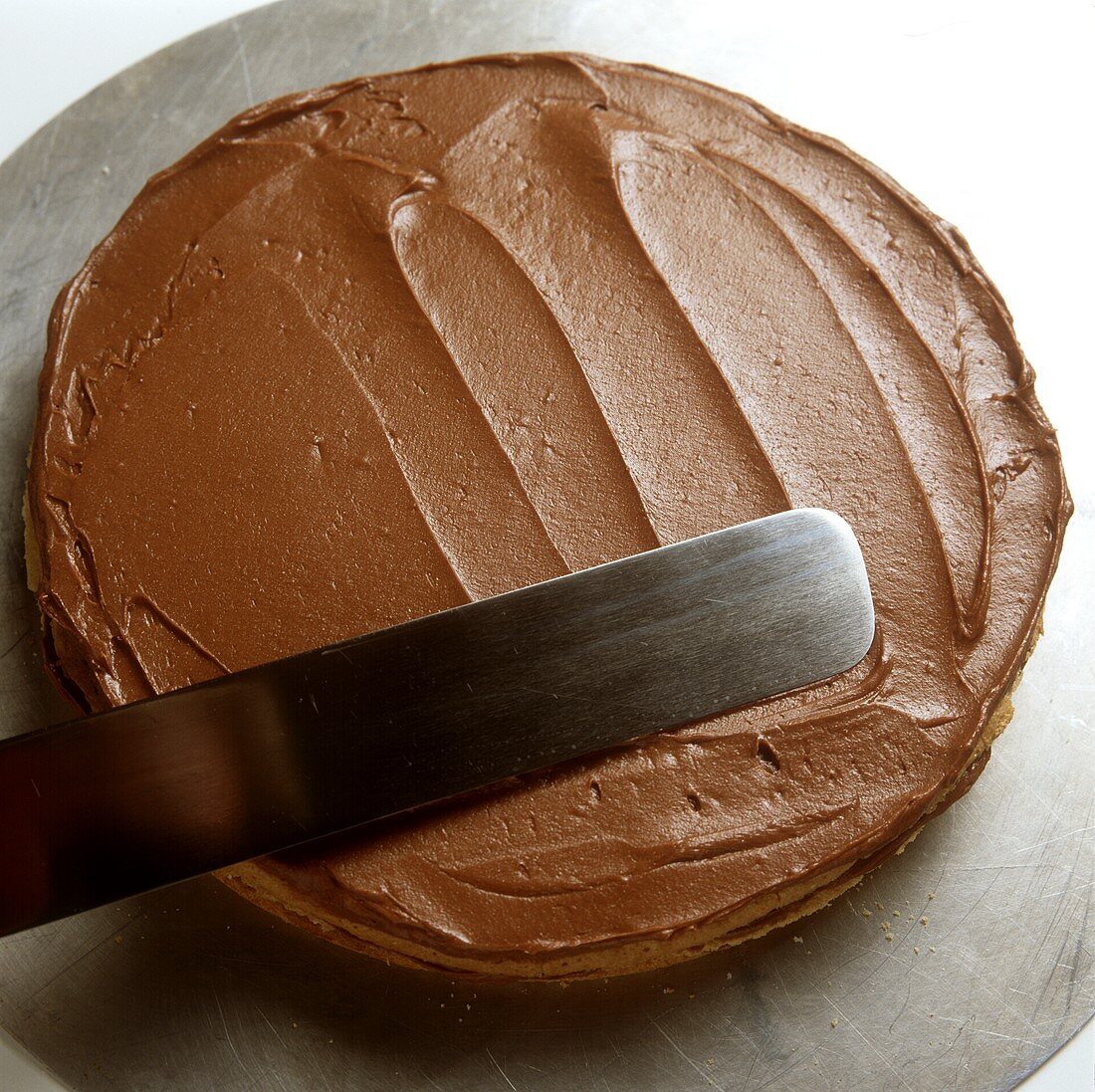 Schokoladencreme auf Torte streichen