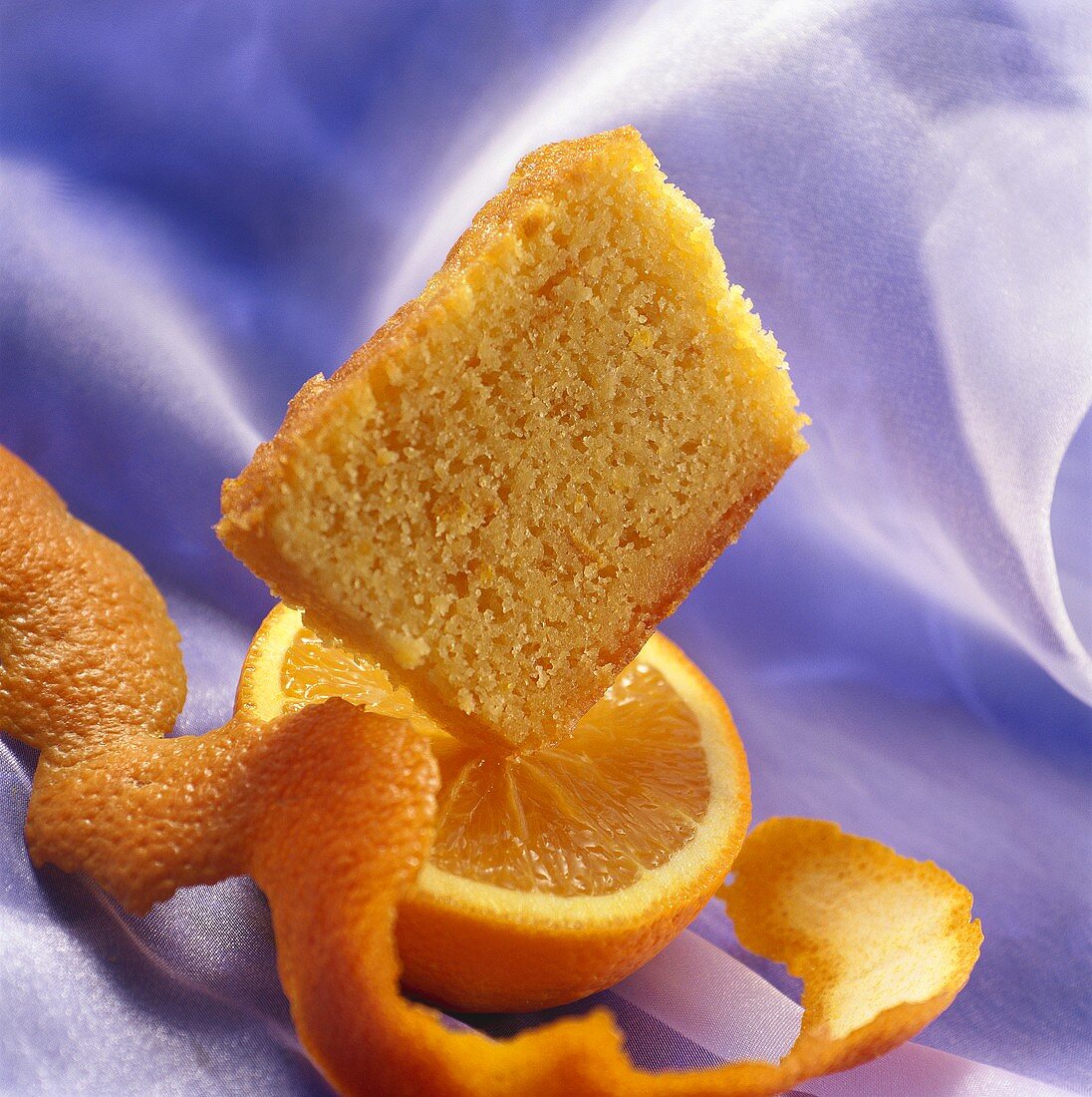 Piece of orange cake on half an orange