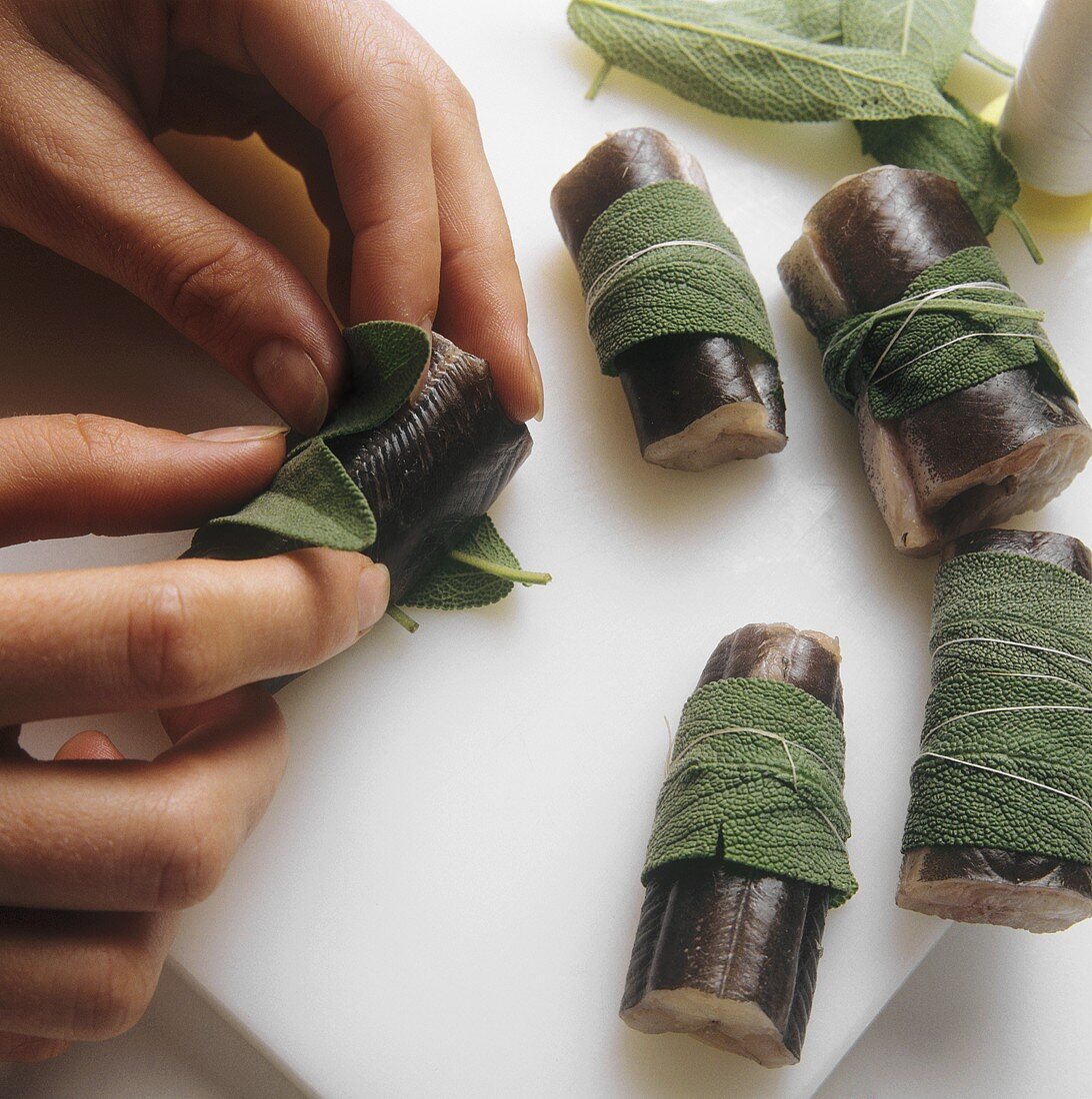 Wrapping sage leaves around pieces of eel