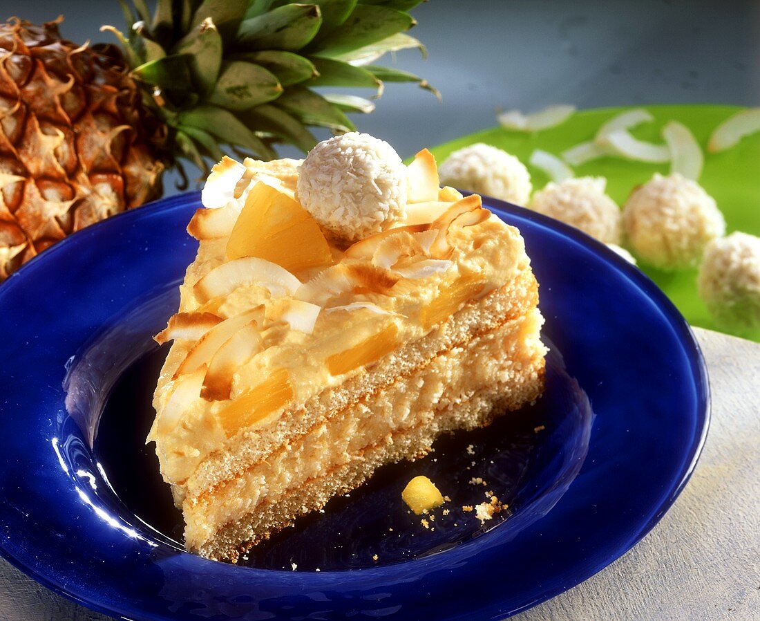 Ein Stück Pina-Colada-Torte mit Ananas und Kokoskugeln