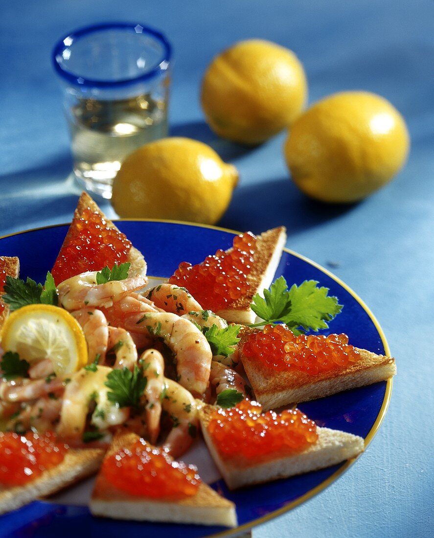Shrimps with lemon and caviare toast on plate