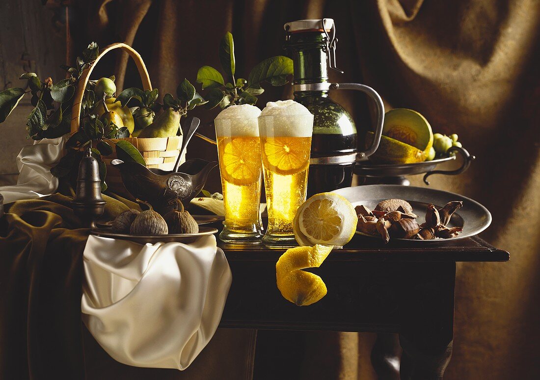Still life of light beer with lemon, fruit and nuts