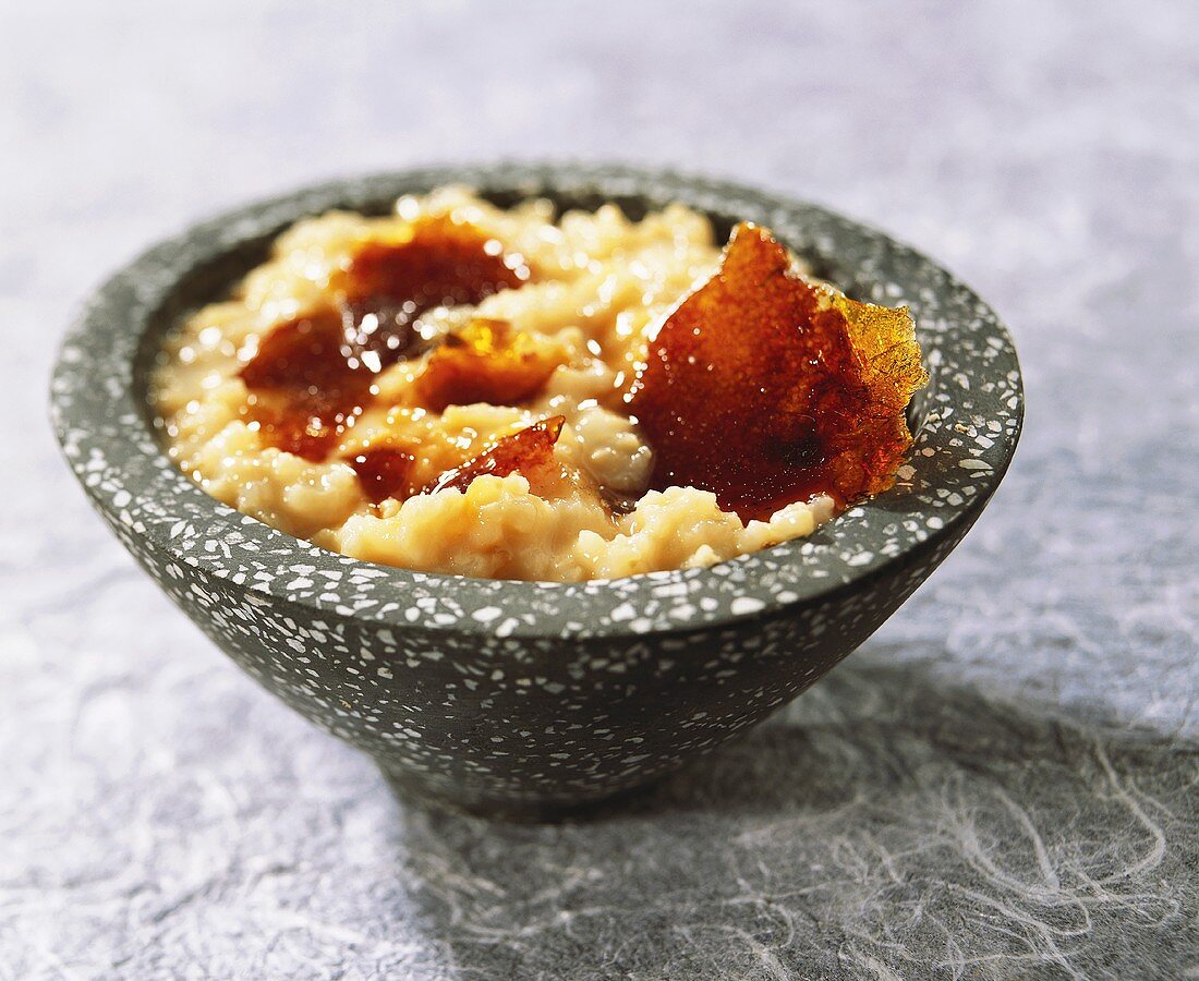 Rice pudding with caramel in a grey bowl