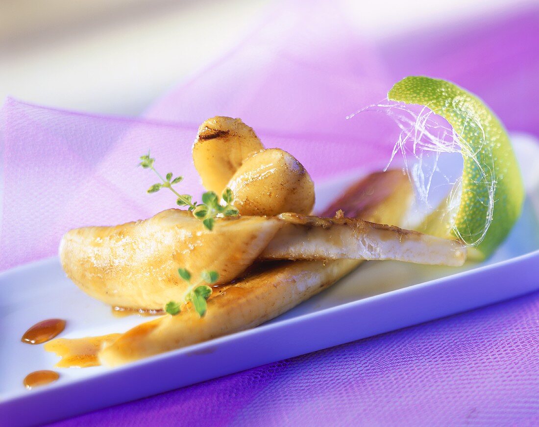 Fried caramelised bananas with a wedge of lime
