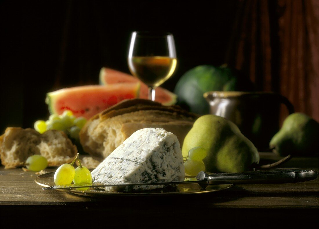 Roquefort mit Obst, Brot und einem Glas Weißwein