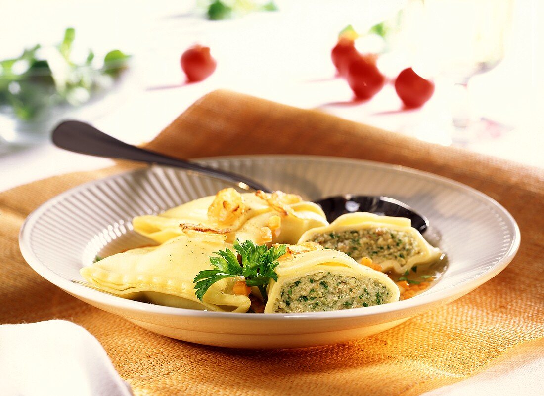 Pasta envelopes (Maultaschen) with parsley in soup plate 