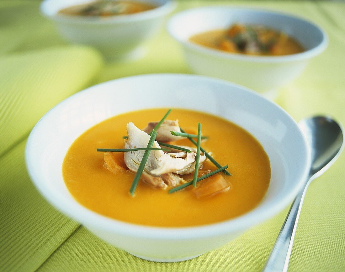 Orange and carrot cream soup with mackerel and chives