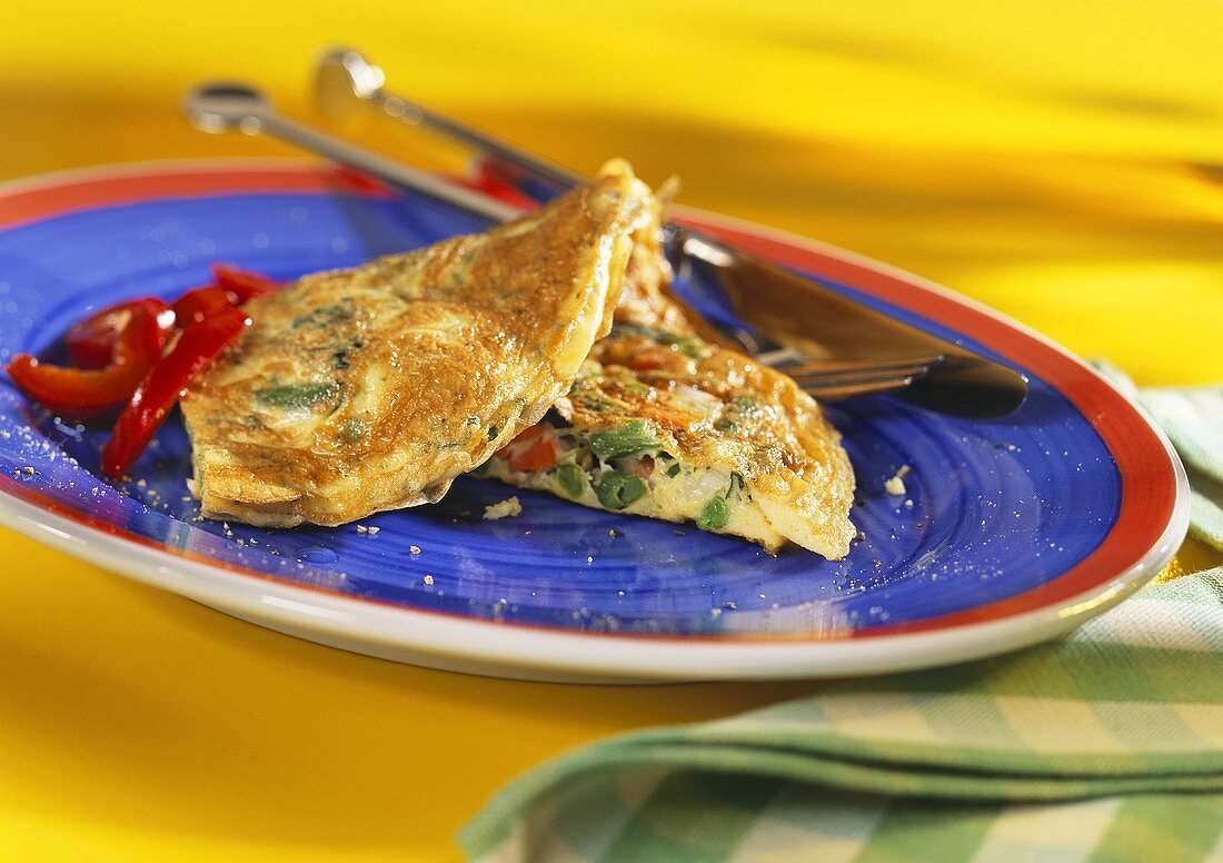 Vegetable omelette on blue plate with cutlery