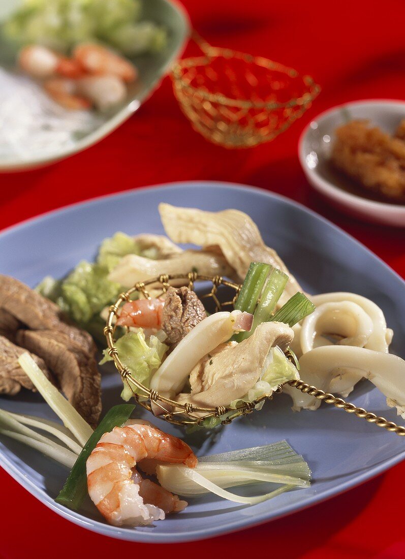 Asiatisches Fondue mit Fleisch, Geflügel, Garnelen, Gemüse