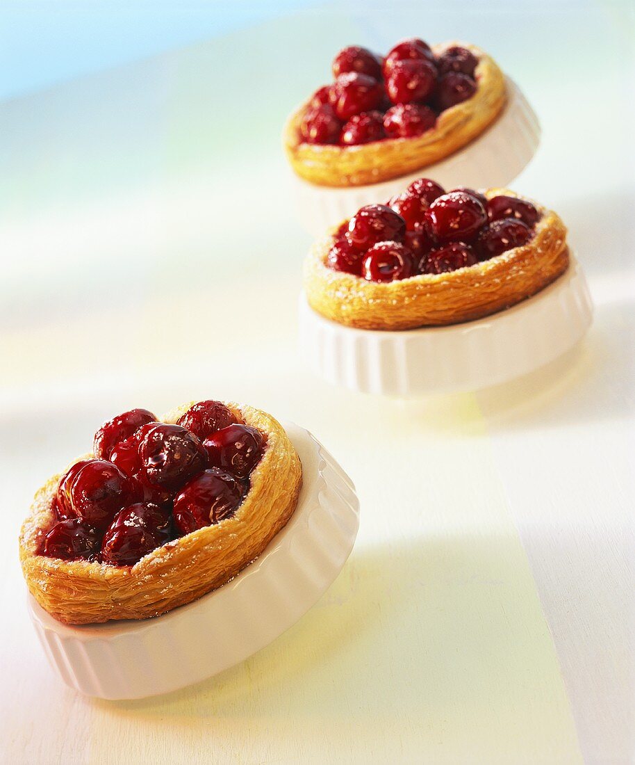 Cherry tarts with icing sugar in the baking tins