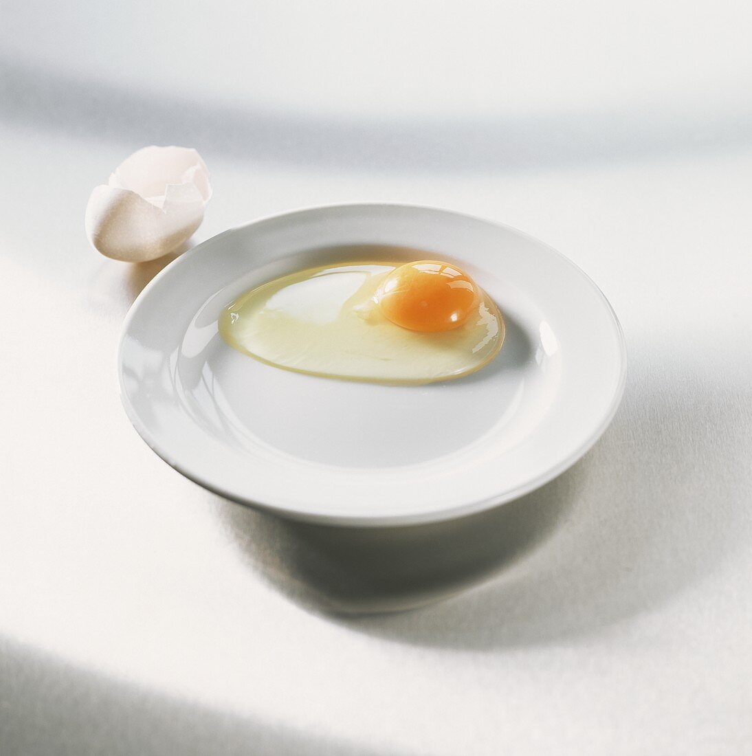 Sehr frisches aufgeschlagenes Ei auf weißem Teller