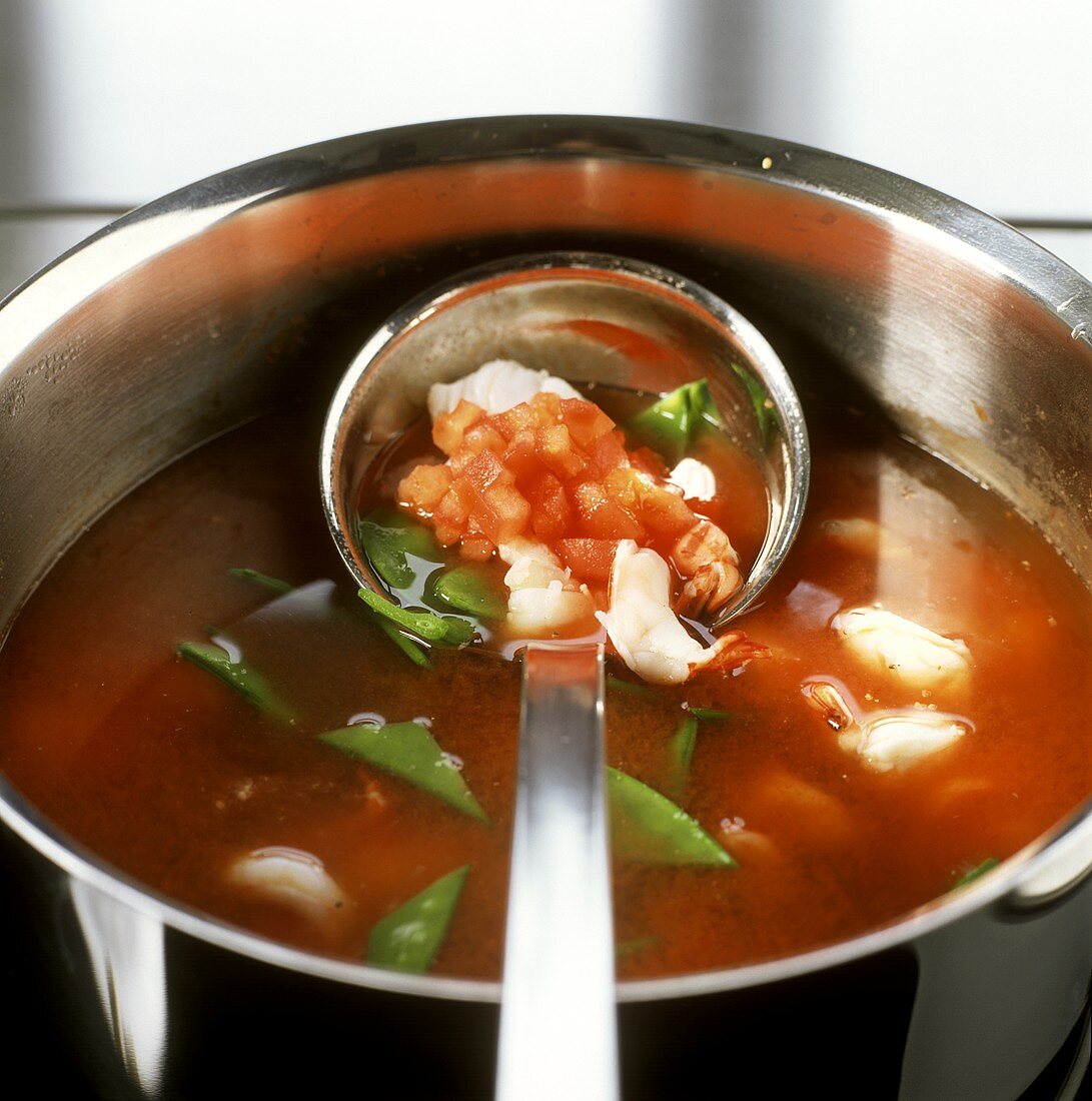 Tomatensuppe mit Fisch und Garnelen zubereiten