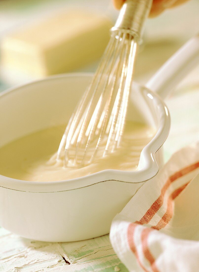 Bechamel sauce in pan with whisk