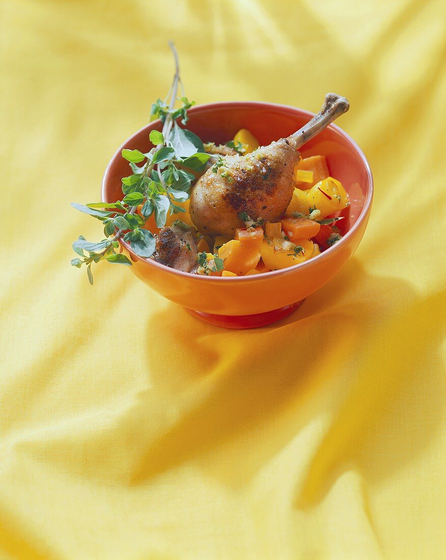 Chicken leg with almonds, vegetables and sprig of oregano