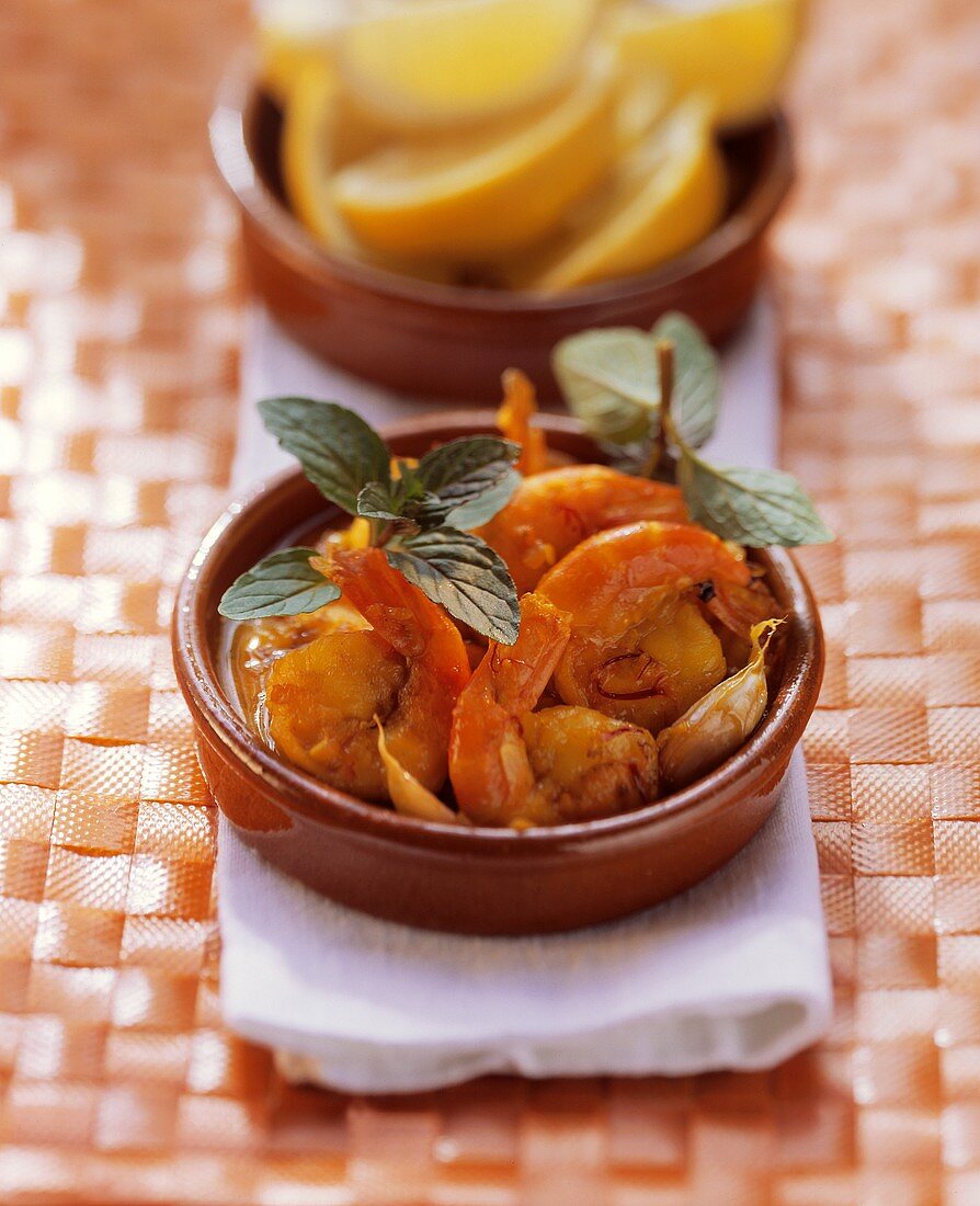 Shrimps with tomato and saffron sauce in terracotta bowl