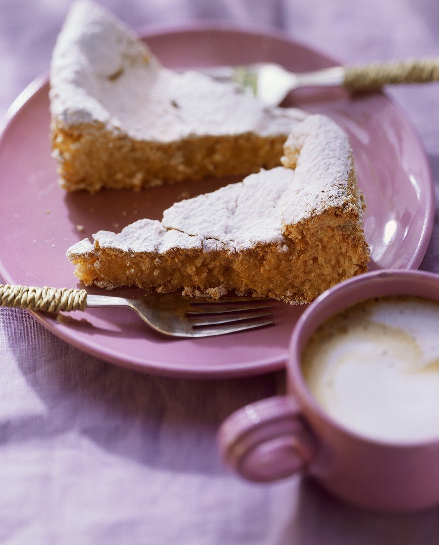 Mandelkuchen mit Puderzucker auf Teller; Kaffee