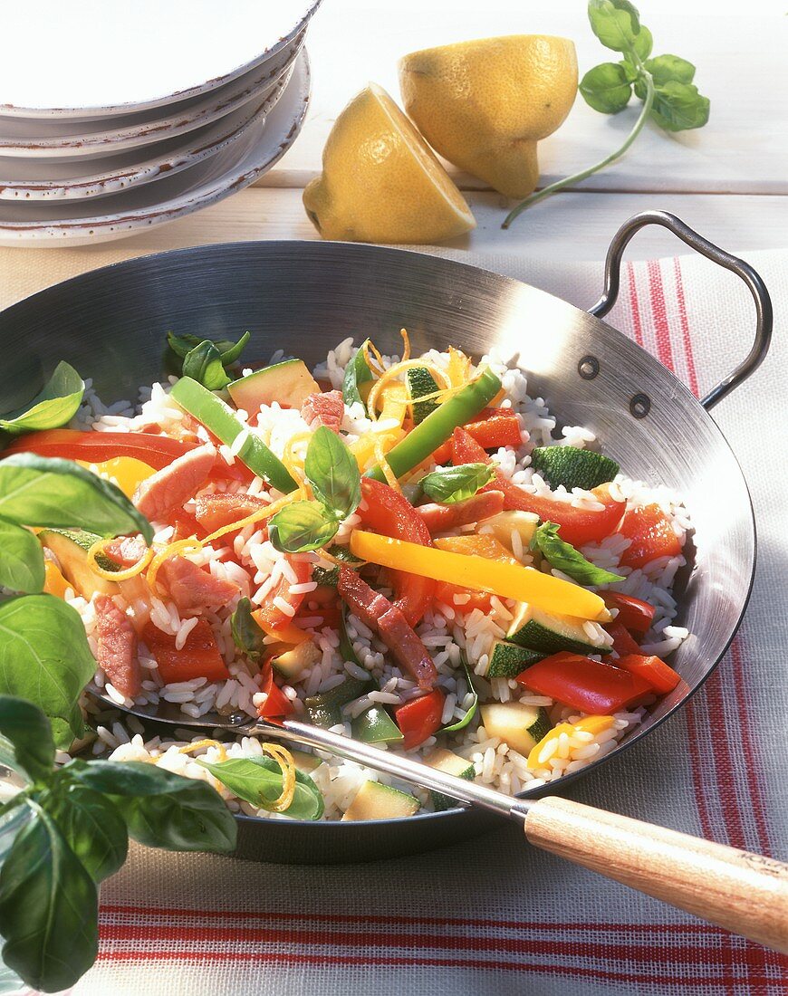 Vegetable paella with diced ham and basil