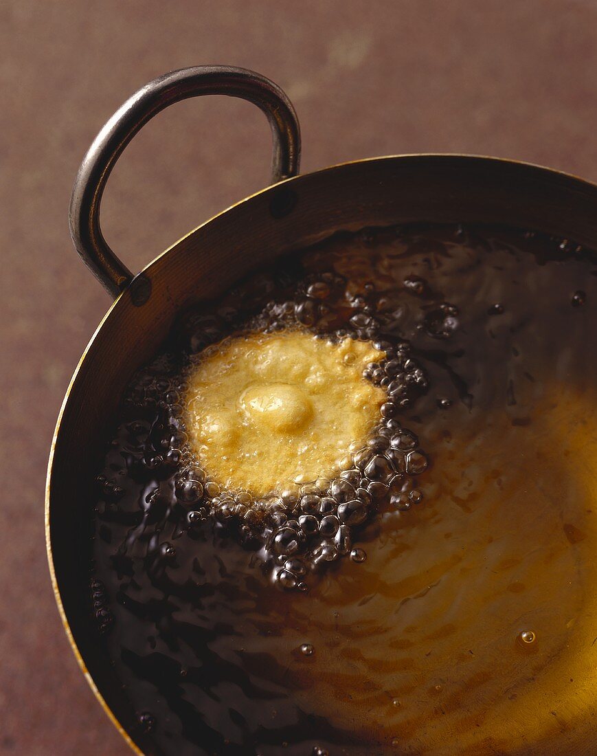 Fritierte Zucchinischeibe in heißem Öl